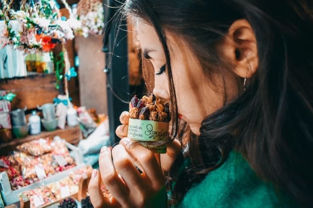 Foto do perfil de uma mulher cheirando produto feito com ervas secas. A foto ilustra o artigo "O que é aromaterapia e quais seus benefícios?" do site Ori Mystyco.