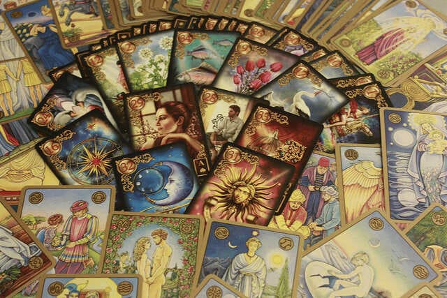 Foto de baralho petit lenormand espalhado em forma de leque em cima de uma mesa. A foto ilustra o artigo Significado das Cartas do Baralho Cigano ou Petit Lenormand do site Ori Mystyco.